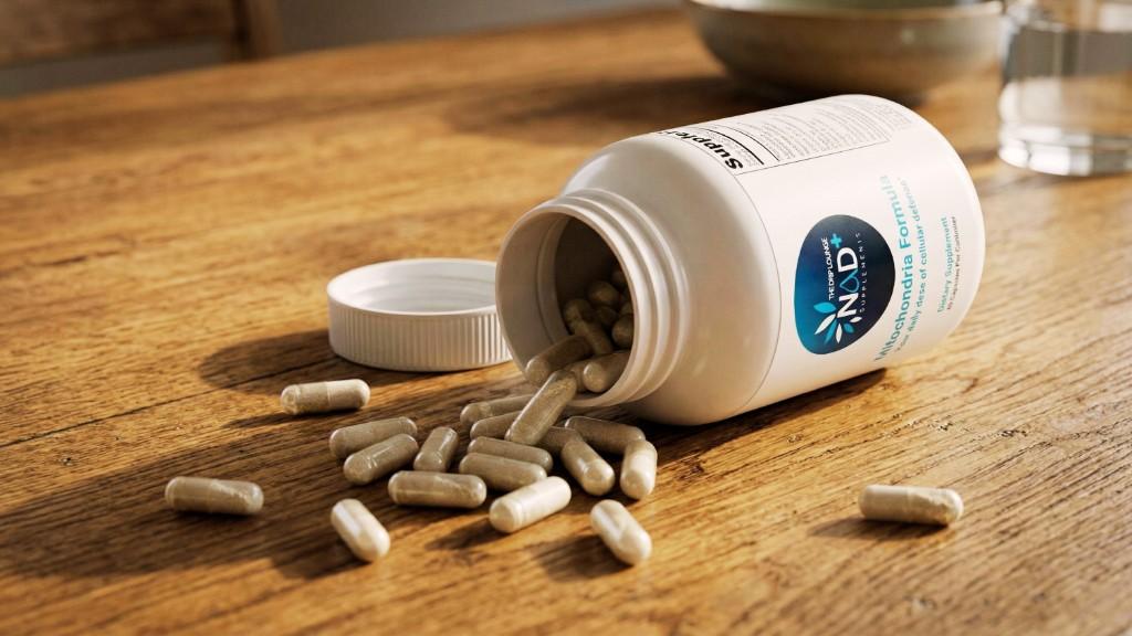 NAD+ Mitochondria Formula capsules spilled from the bottle on a wooden table